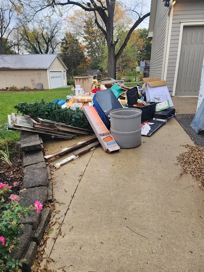 Dumpster being loaded with debris for Estate Cleanout Dumpster Rental in Bedford